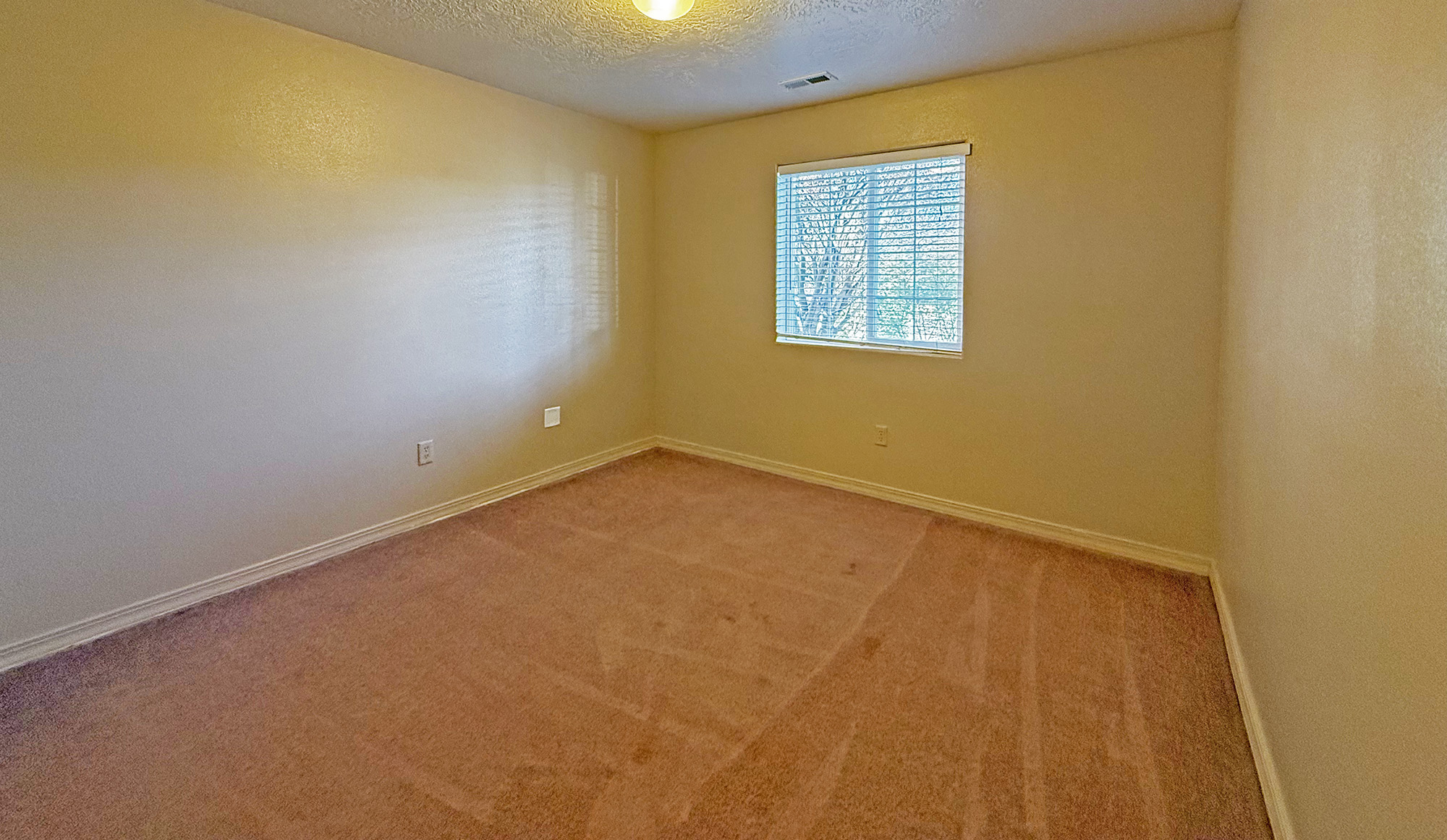 Second bedroom from doorway with window overlooking street